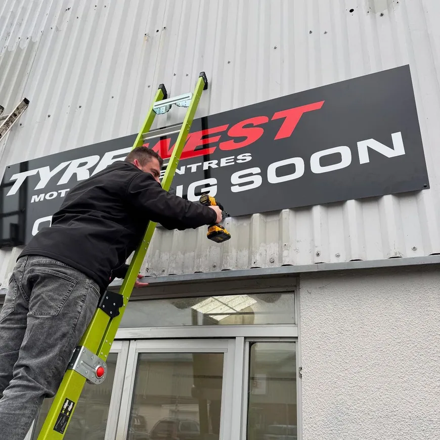 Crew installing channel letters on a building façade