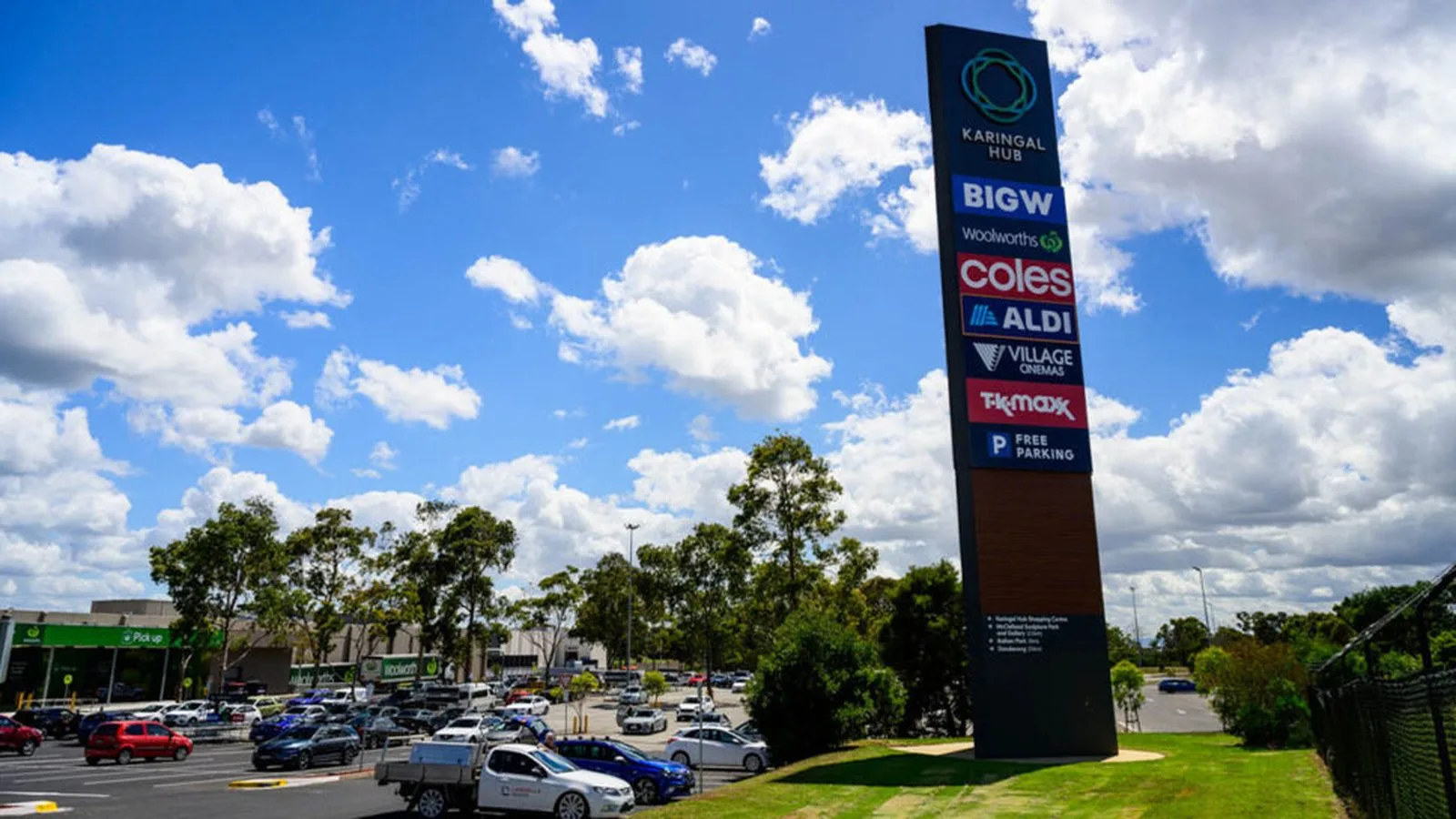 Tall multi-tenant retail pylon sign with stacked tenant panels